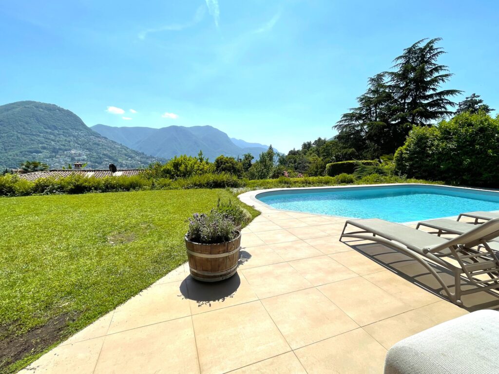 giardino con piscina, patio e vista sulle montagne, esempio di progettazione ville di Immobiliare De Bernardis