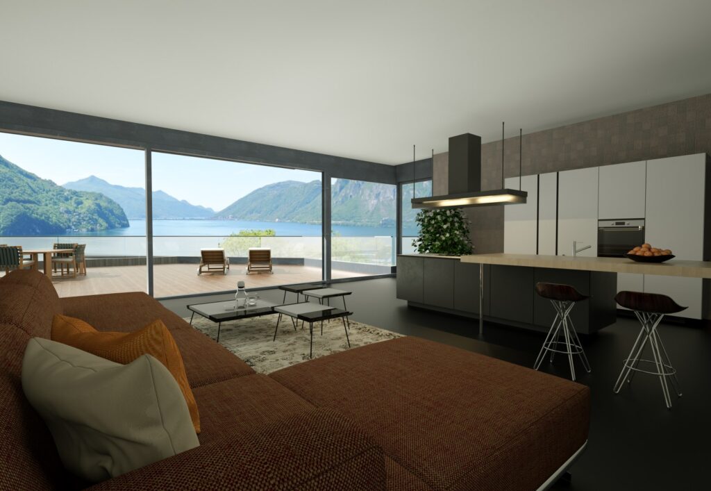 ampio spazio soggiorno e cucina, mobili moderni e grande vetrata sul lago, un esempio di ville sul lago di lugano di immobiliare de bernardis